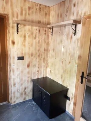 a room with a wooden wall with a black desk at Dom Pod Wierzbami in Sidzina