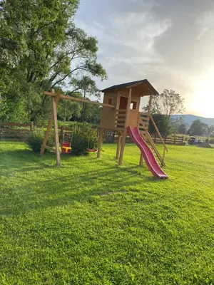 a playground with a slide in a field at Dom Pod Wierzbami in Sidzina