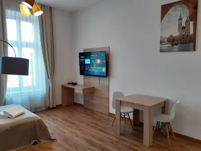 a room with a table and a tv and a bed at Old Town Apartments - B20 in Kraków