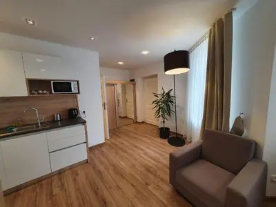 a living room with a couch and a kitchen at Old Town Apartments - B34 in Kraków