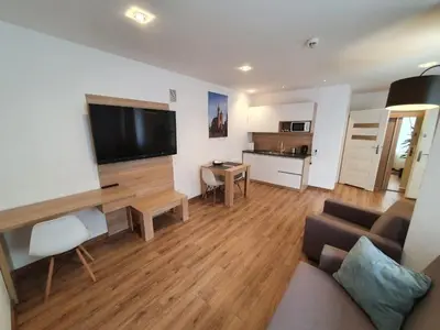 a living room with a couch and a flat screen tv at Old Town Apartments - B34 in Kraków