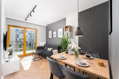 a dining room and living room with a table and chairs at Quantum Premium Apartment & Free Parking! in Kraków