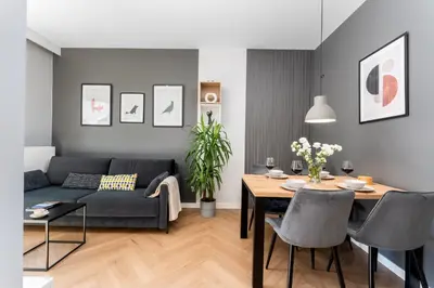 a living room with a blue couch and a table at Quantum Premium Apartment & Free Parking! in Kraków