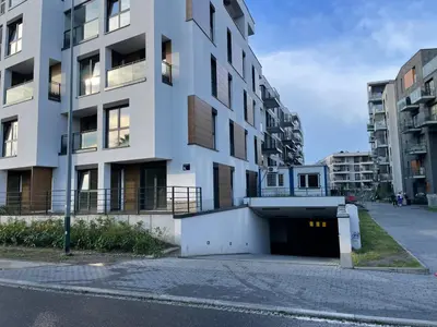 an apartment building with a garage in front of it at Quantum Premium Apartment & Free Parking! in Kraków