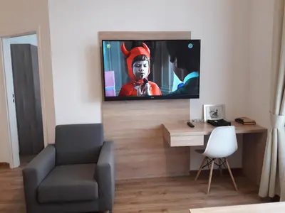 a living room with a flat screen tv on a wall at Old Town Apartments - B19 in Kraków
