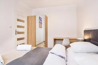 a bedroom with two beds with white sheets at Old Town Apartments - B19 in Kraków