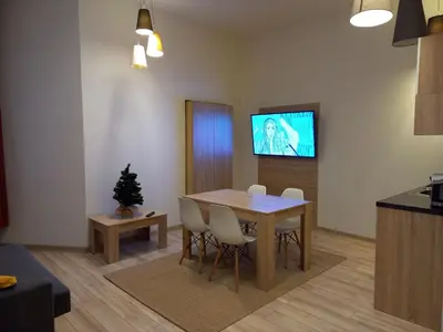 a living room with a dining room table and a television at Old Town Apartments - B7 in Kraków