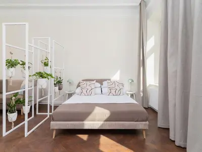 a white bedroom with a large bed and plants at 3 bedroom apartment - Rejtana 10 in Kraków