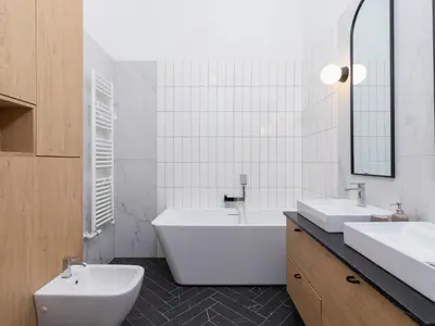 a bathroom with two sinks and a tub and a toilet at 3 bedroom apartment - Rejtana 10 in Kraków