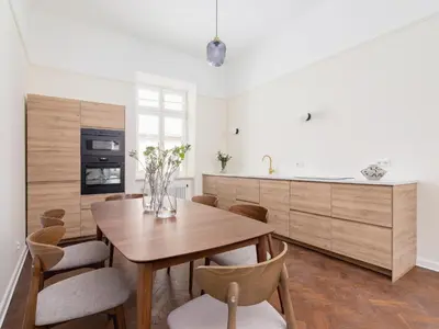 a kitchen with a wooden table and some chairs at 3 bedroom apartment - Rejtana 10 in Kraków
