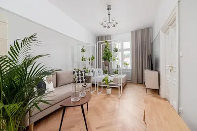 a living room with a couch and some plants at 3 bedroom Apartment with the balcony - Rejtana 10 in Kraków