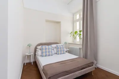 a small bedroom with a bed and a window at 3 bedroom Apartment with the balcony - Rejtana 10 in Kraków