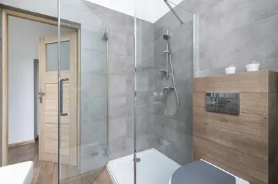 a bathroom with a glass shower with a toilet at 1 Bedroom Apartment - Ludwika Zamenhofa 6 street in Kraków
