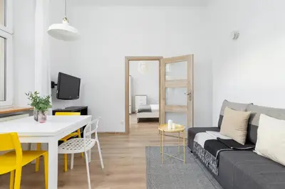 a living room with a couch and a table at 1 Bedroom Apartment - Ludwika Zamenhofa 6 street in Kraków