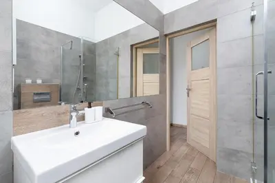 a bathroom with a white sink and a shower at 1 Bedroom Apartment - Ludwika Zamenhofa 6 street in Kraków