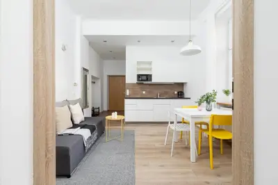 a living room and kitchen with a couch and a table at 1 Bedroom Apartment - Ludwika Zamenhofa 6 street in Kraków