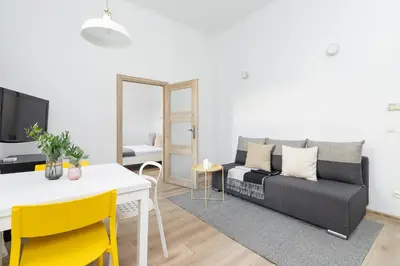 a living room with a couch and a table at 1 Bedroom Apartment - Ludwika Zamenhofa 6 street in Kraków