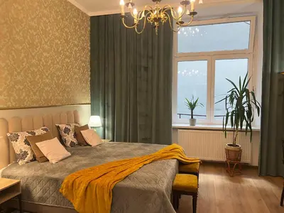a bedroom with a bed and a window at Wawel Crown Apartments in Kraków