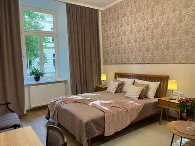 a bedroom with a bed and a window at Wawel Crown Apartments in Kraków