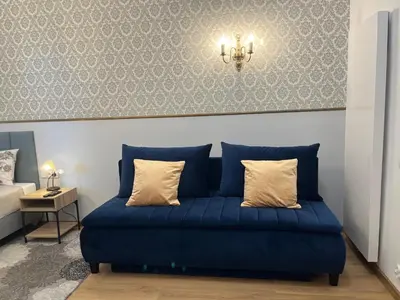 a blue couch with two pillows in a room at Wawel Crown Apartments in Kraków