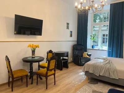 a bedroom with a bed and a table and chairs at Wawel Crown Apartments in Kraków