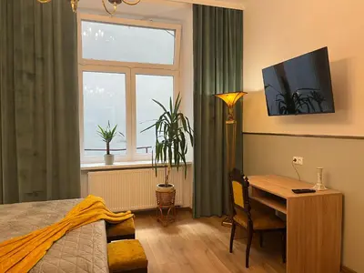a bedroom with a desk and a table and a window at Wawel Crown Apartments in Kraków