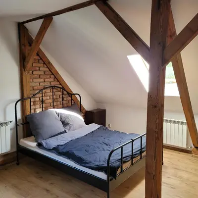 a bedroom with a metal bed in a attic at Dom dla 6 osób in Oświęcim
