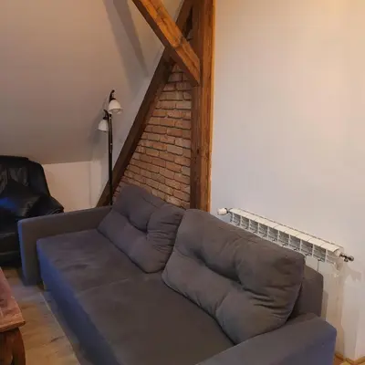a couch in a living room with a brick wall at Dom dla 6 osób in Oświęcim