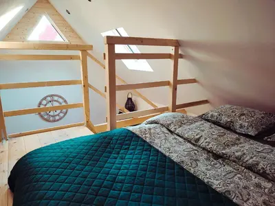 a bedroom with a green bed and a ladder at Domek Pocieszna Podkowa in Rabka-Zdroj