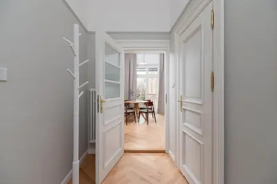 a hallway with white doors and a dining room at 2 - bedroom Apartment with balcony - Rejtana 10 in Kraków