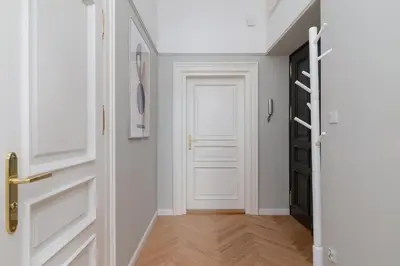 a hallway with white doors and wooden floors at 2 - bedroom Apartment with balcony - Rejtana 10 in Kraków