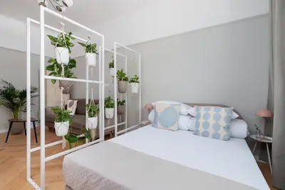 a white room with a bed and potted plants at 2 - bedroom Apartment with balcony - Rejtana 10 in Kraków