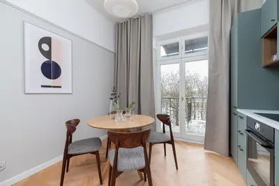 a kitchen and dining room with a table and chairs at 2 - bedroom Apartment with balcony - Rejtana 10 in Kraków