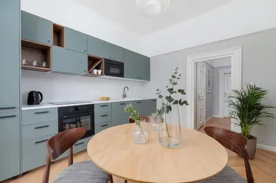 a kitchen with a wooden table and chairs at 2 - bedroom Apartment with balcony - Rejtana 10 in Kraków