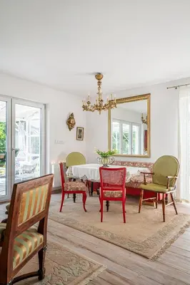 a dining room with a table and chairs and a mirror at Villa Marta in Trzebinia