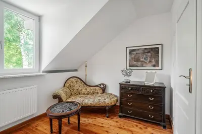 a living room with a chair and a dresser at Villa Marta in Trzebinia