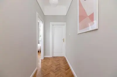 a hallway with a white door and a picture on the wall at 2 - bedroom Apartment with balcony - Rejtana 10 in Kraków