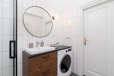 a bathroom with a washing machine and a mirror at 2 - bedroom Apartment with balcony - Rejtana 10 in Kraków
