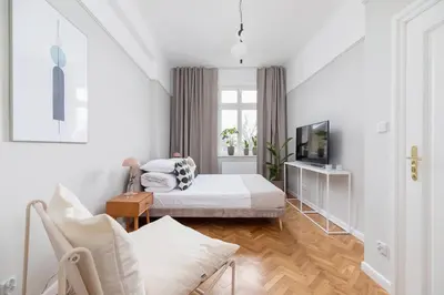 a white room with a bed and a tv at 2 - bedroom Apartment with balcony - Rejtana 10 in Kraków