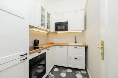a small kitchen with white cabinets and a sink at 2 - bedroom Apartment with balcony - Rejtana 10 in Kraków