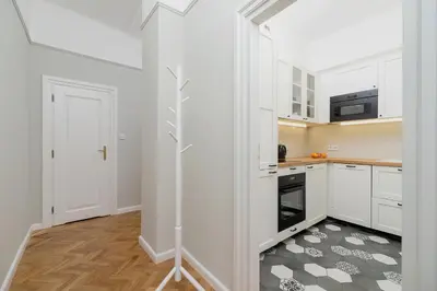 a kitchen with white cabinets and a stove top oven at 2 - bedroom Apartment with balcony - Rejtana 10 in Kraków