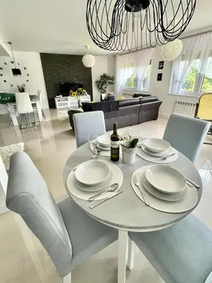a dining room table with chairs and a bottle of wine at Domek u Gosi in Zator