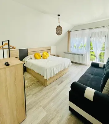 a bedroom with a bed with yellow pillows and a couch at Domek u Gosi in Zator