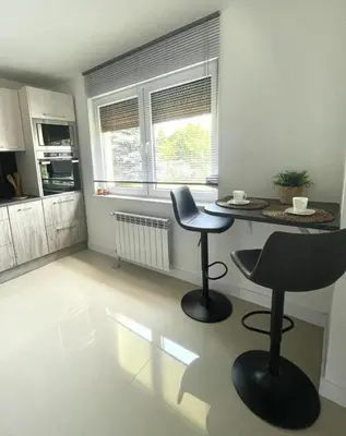 a kitchen with two chairs and a table in a room at Domek u Gosi in Zator