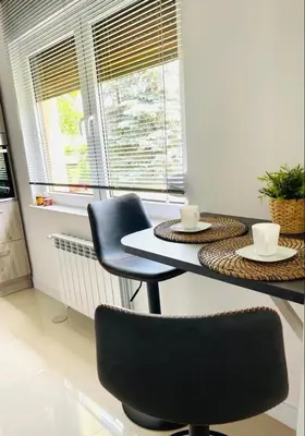 a table with two chairs and two cups on it at Domek u Gosi in Zator