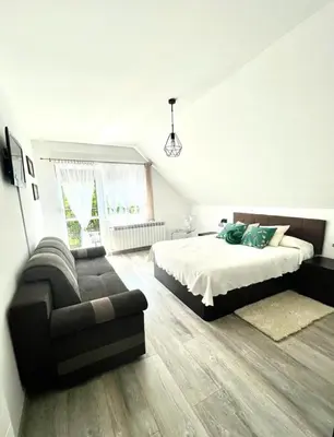 a bedroom with a bed and a couch at Domek u Gosi in Zator