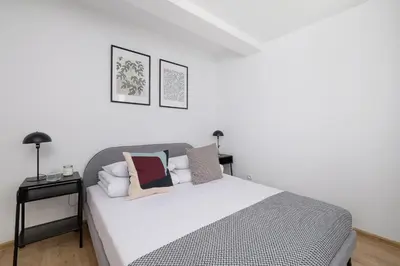 a bedroom with a white bed with pillows on it at 4 bedroom apartment with a balcony - Prochowa 1 in Kraków