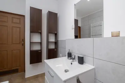 a bathroom with a white sink and a mirror at 4 bedroom apartment with a balcony - Prochowa 1 in Kraków
