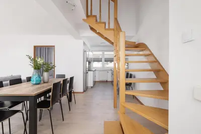 a wooden staircase in a dining room with a table at 4 bedroom apartment with a balcony - Prochowa 1 in Kraków