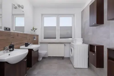 a bathroom with a sink and a toilet and windows at 4 bedroom apartment with a balcony - Prochowa 1 in Kraków